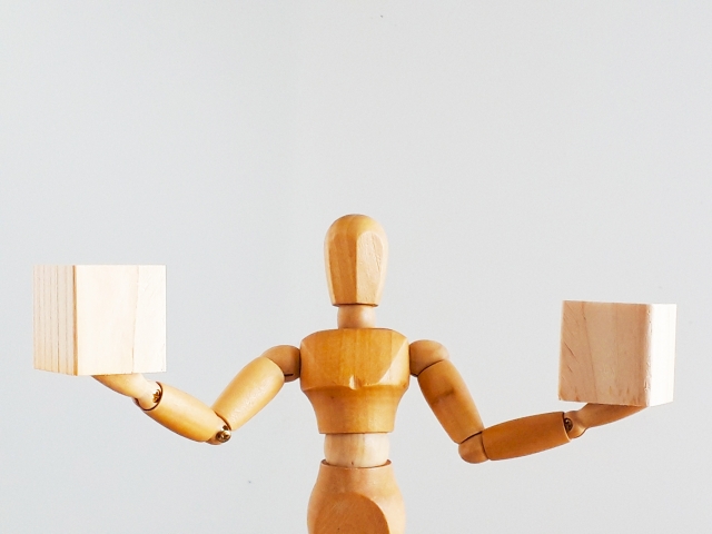 両手で木のブロックを持つ人形