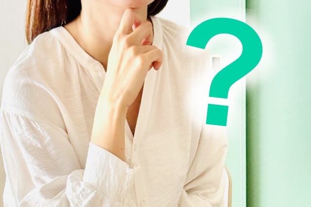 考え込む女性と緑のクエスチョンマーク