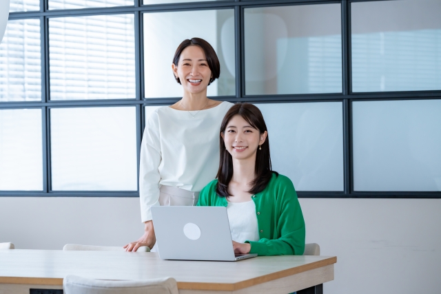 職場で親しげに座る二人の女性