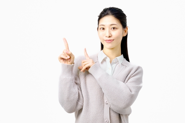 指をさして案内する女性