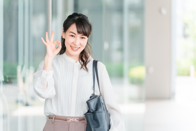 オフィスで笑顔で手を振る女性